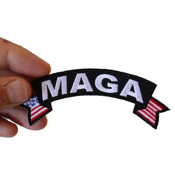 A hand holding a Trump MAGA patch